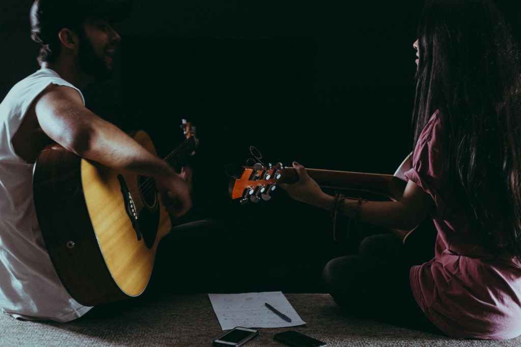 man and woman playing guitar